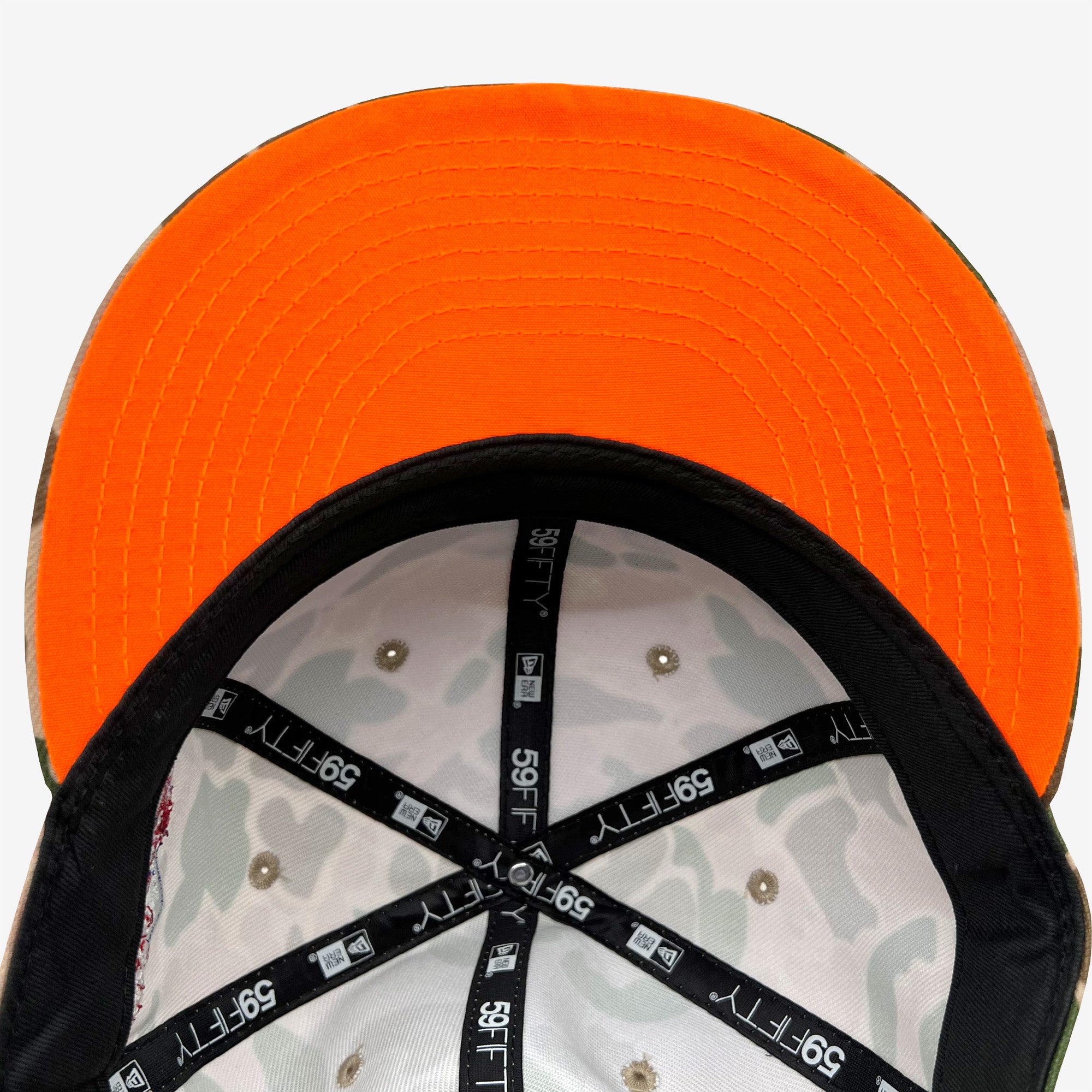 The bright neon orange underside of the bill on a fitted cap with a view of the inside of the crown with New Era 5950 taping.