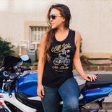 Women on a motorbike in a black tank top with yellow and white All Gas No Breaks Oakland Crew skeleton riding a bike graphic.