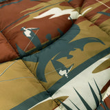 Detailed close-up of a puffy blanket with Oakland cityscape in blue, gold, rust and white.
