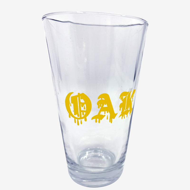 Clear glass pint beer glass with gold OAK wordmark in a bleed font.