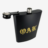 Black flask with gold OAK wordmark in a bleeding font with the screw-off hinged lid open. 
