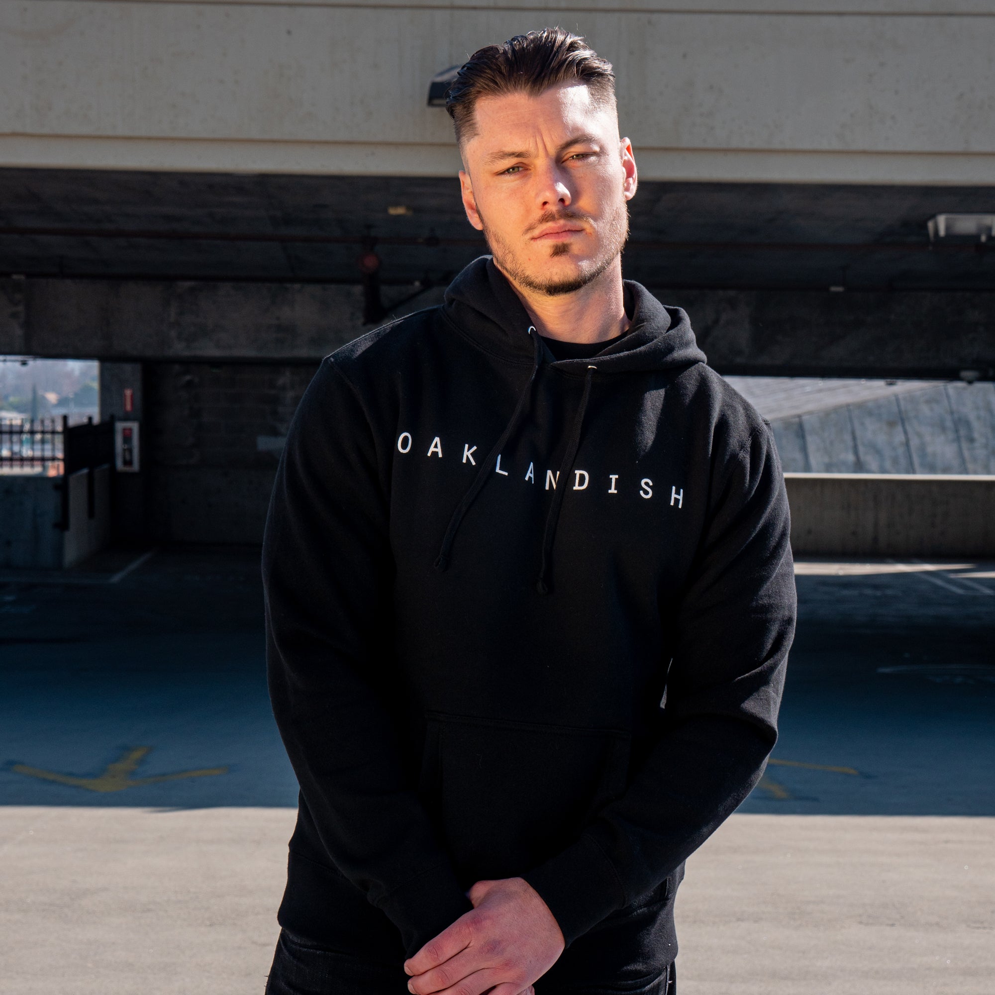 Male model wearing black hoodies with white capitalized OAKLANDISH wordmarks on the chest.