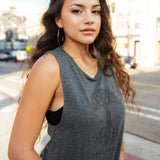 Female model wearing Grey women’s cut tank top with black classic Oaklandish tree logo and wordmark on chest.
