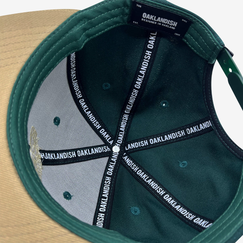 Inside forest snapback hat crown with ‘OAKLANDISH’ wordmark on black striping and Oaklandish patch.