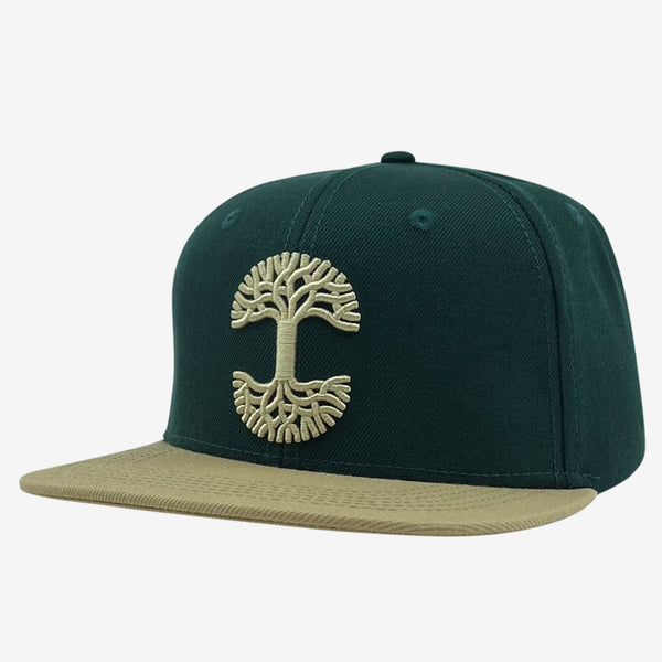 Side view of forest snapback hat with khaki embroidered Oaklandish tree logo on crown and contrasting khaki brim.