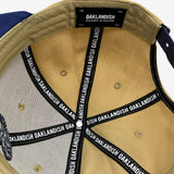 Inside tan snapback hat crown with ‘OAKLANDISH’ wordmark on black striping and Oaklandish patch.