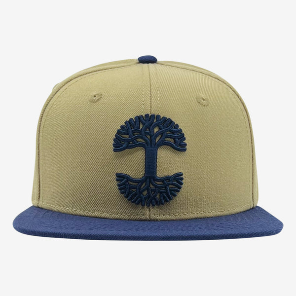 Tan snapback hat with navy embroidered Oaklandish tree logo on crown and navy bill.