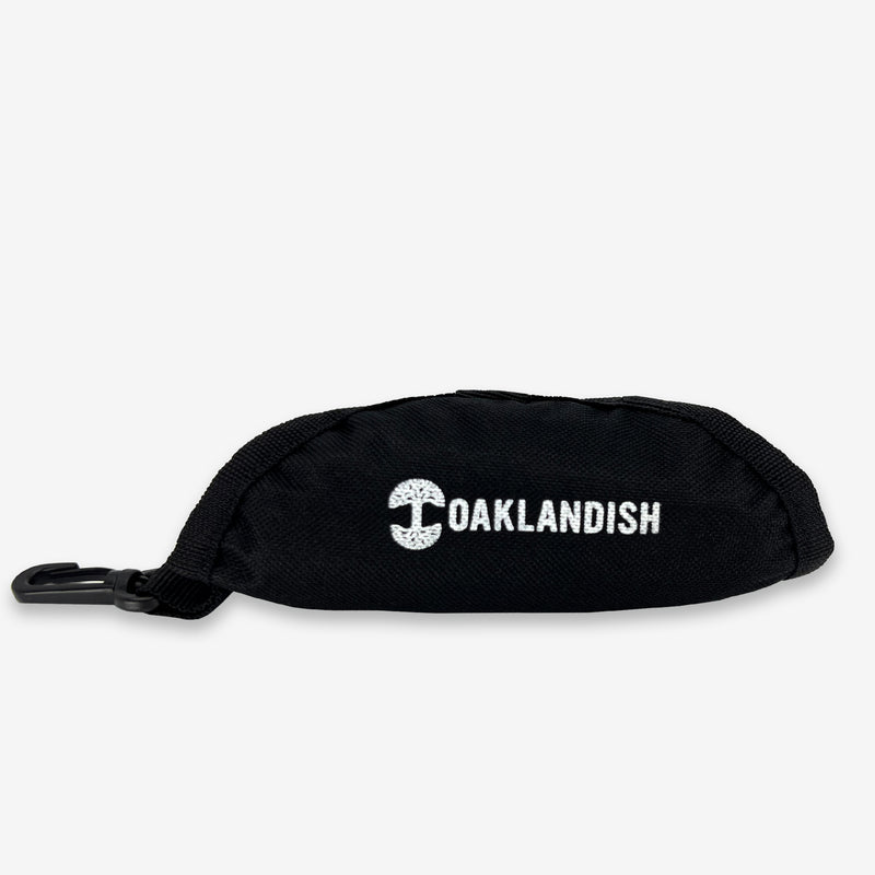 Carry bag for black travel pet bowl with plastic clip and white Oaklandish wordmark and logo.