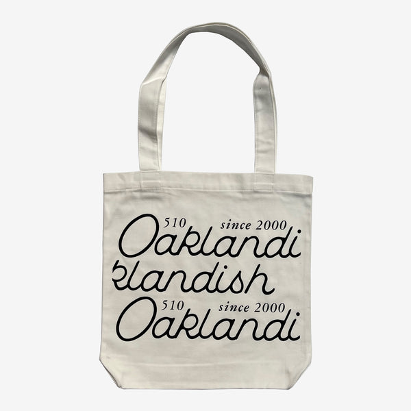 The front side of a cotton shopping tote bag with cursive Oaklandish 510 Since 2000 wordmark.