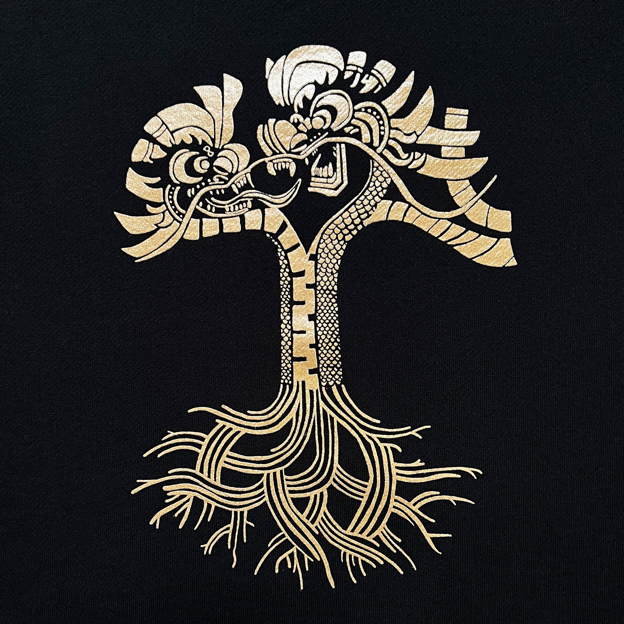 Close-up of metallic gold dragon power design in the shape of the Oaklandish tree logo on a black crewneck sweatshirt.