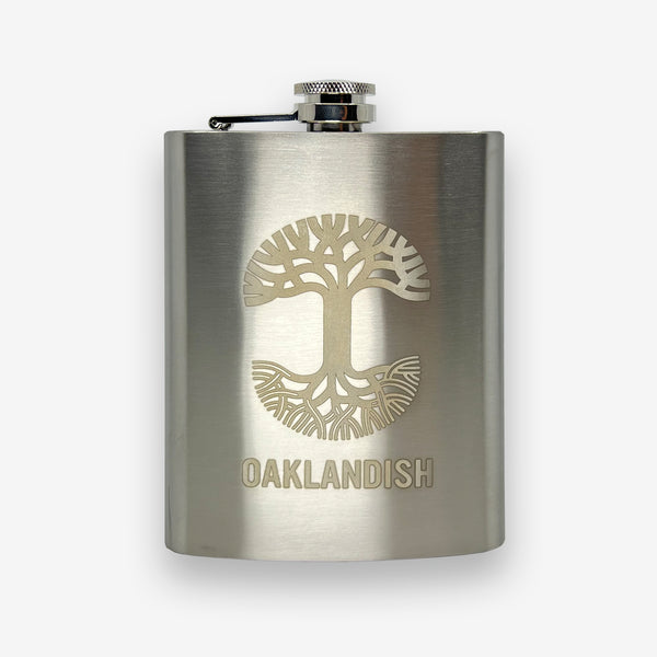 Silver 8 oz hip flask with screw top lid and gold Oaklandish tree logo and wordmark.
