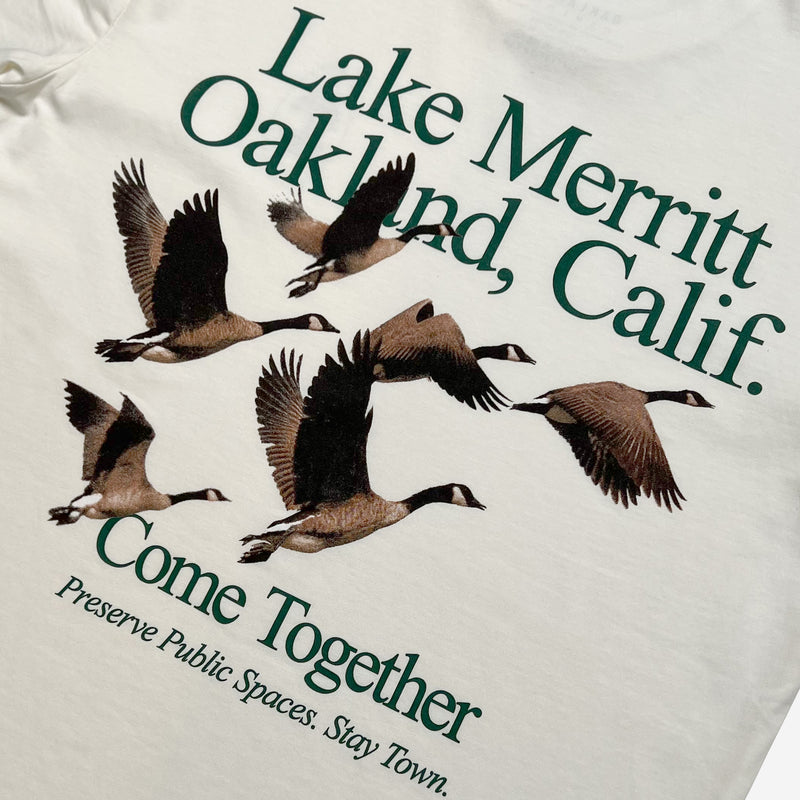 Close up of t-shirt graphic saying “Lake Merrit Oakland Calif. Come together. Preserve Public Spaces. Stay Town.” with flock of geese. 