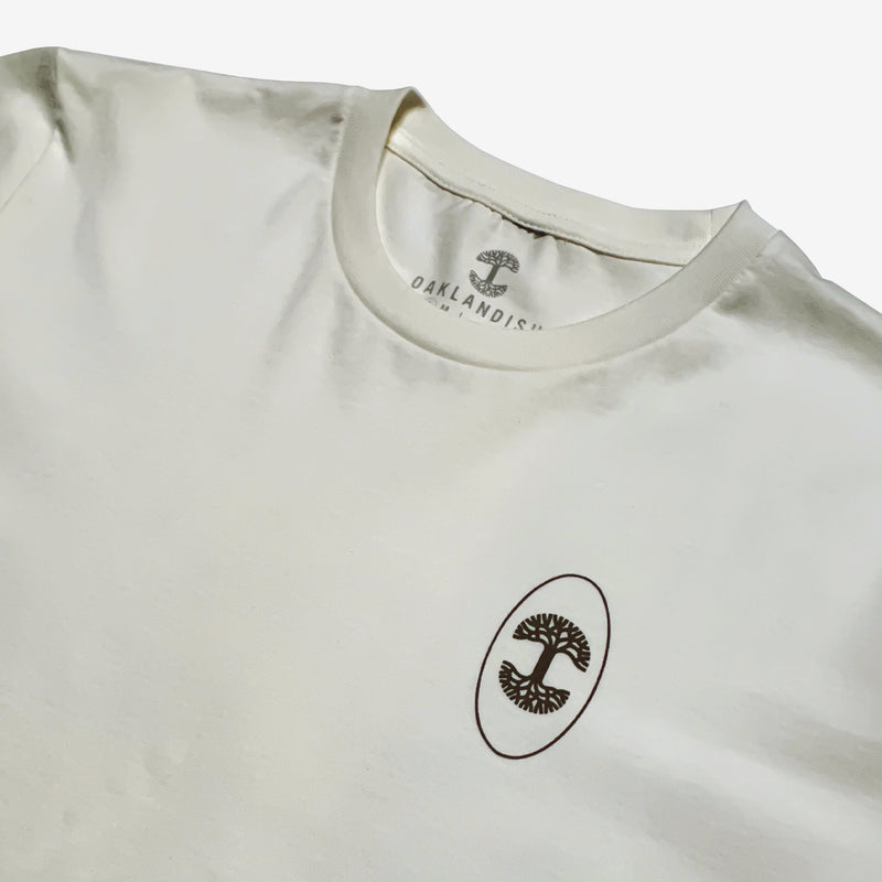 Close up of black Oaklandish tree logo in black oval circle on natural cotton t-shirt.