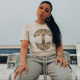 Female model wearing men's bone t-shirt with floral pattern inside classic Oaklandish tree logo.
