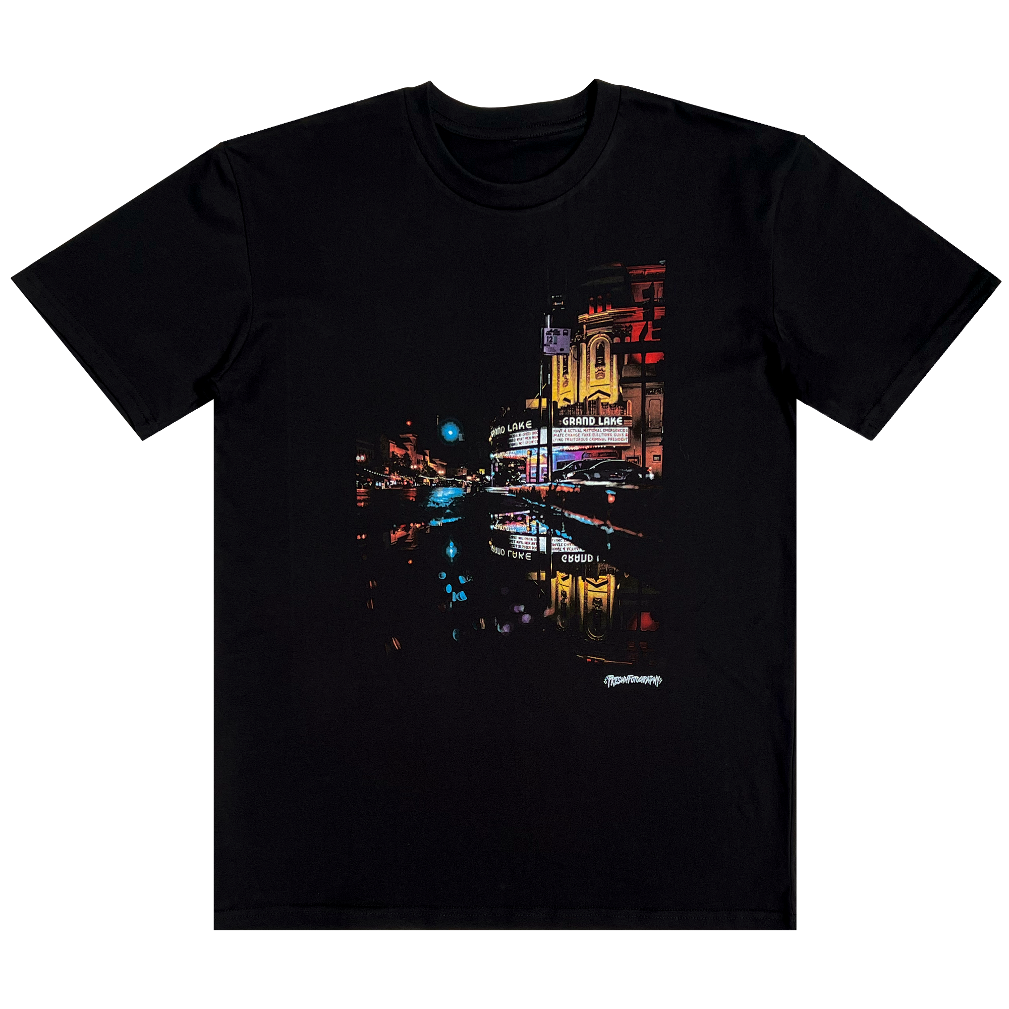 Front view of short sleeve black t-shirt with image of a rainy night reflecting street lights and The Grand Laker Theatre in Oakland.
