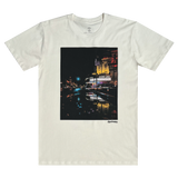 Front view of a natural cotton t-shirt with an image of a rainy night reflecting street lights and The Grand Laker Theatre in Oakland.