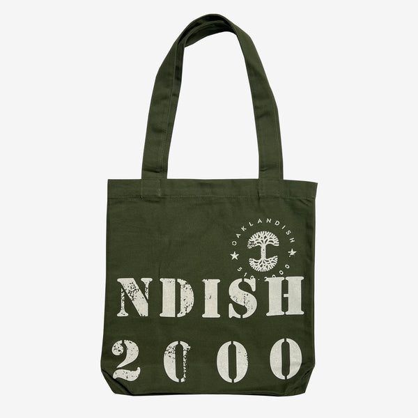 The backside side of an olive green cotton shopping tote bag with capitalized NDISH 2000 and tree logo.