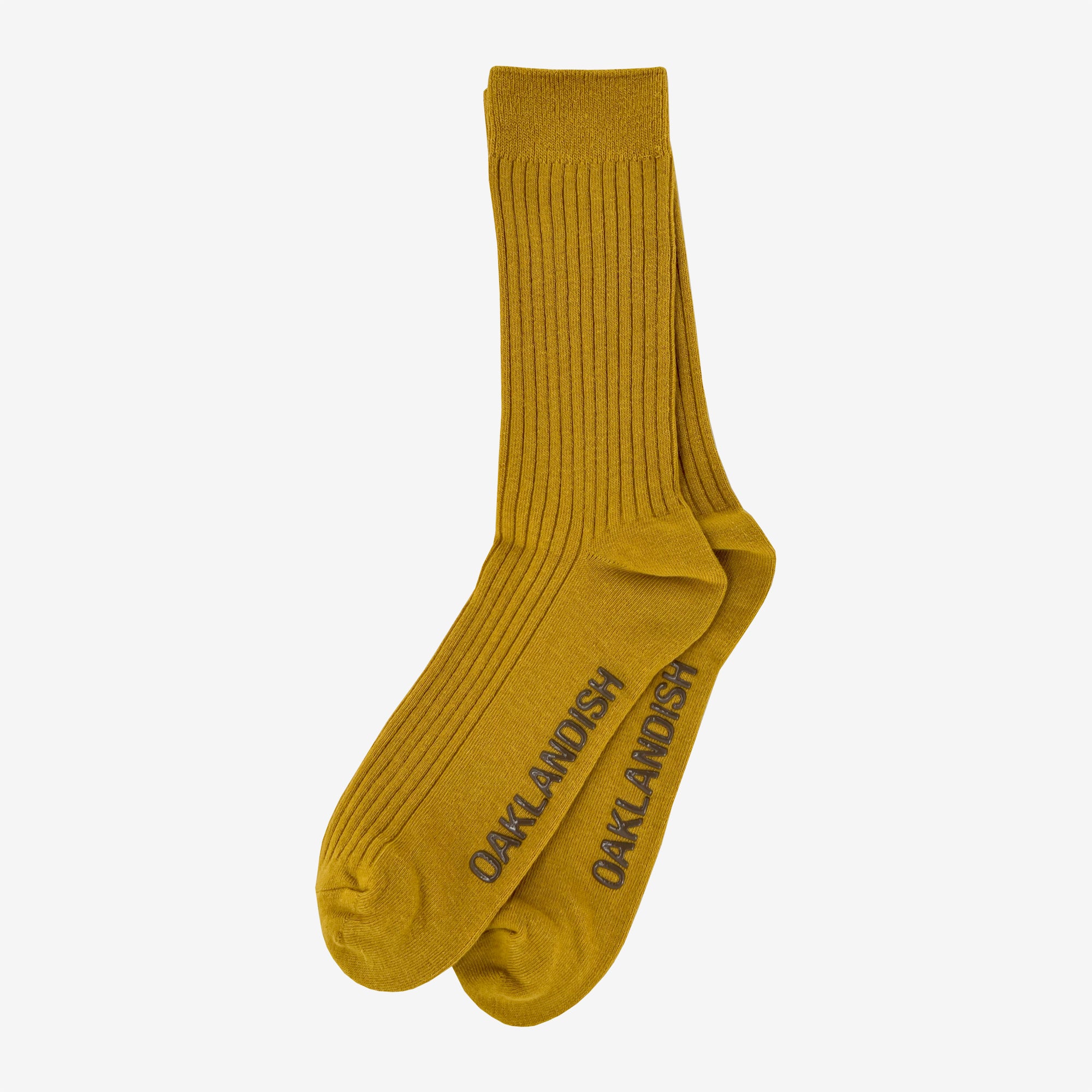 Yellow men's crew socks, one layered on other with brown Oaklandish wordmark on sole.