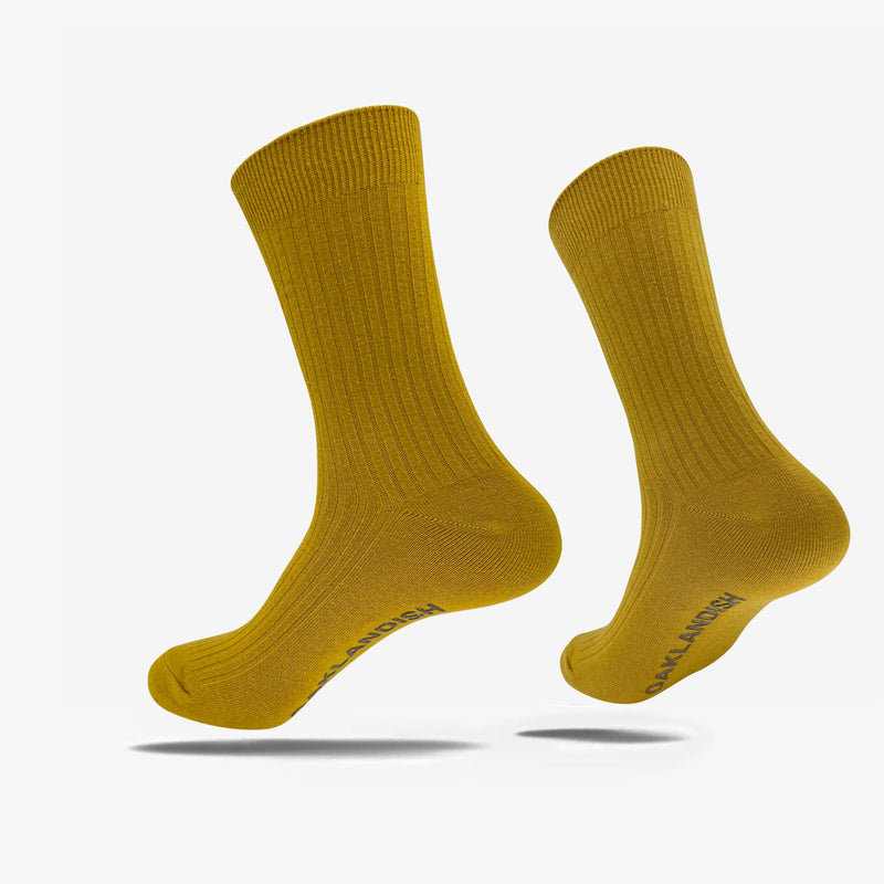 High cut yellow men's crew socks with brown Oaklandish wordmark on sole.