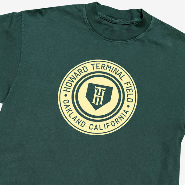 Close-up of green t-shirt with yellow Howard Terminal Field, Oakland California logo, and wordmark on the chest.