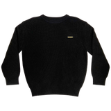 Heavy cotton knit sweater with embroidered Oaklandish wordmark woven label patch on front left chest in black.