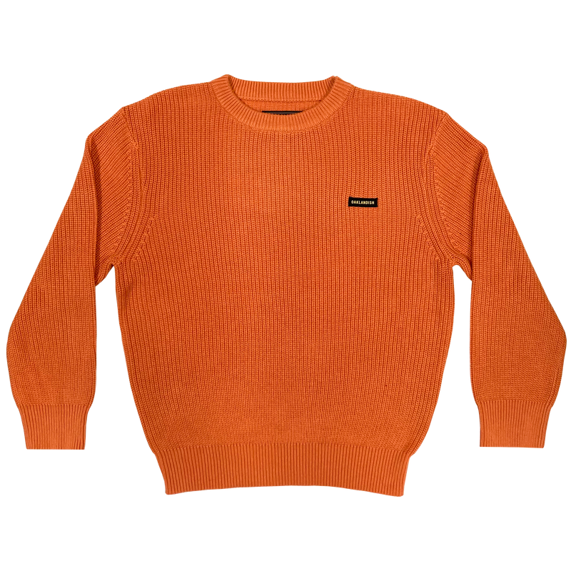 Heavy cotton knit sweater with embroidered Oaklandish wordmark woven label patch on front left chest in autumn orange.