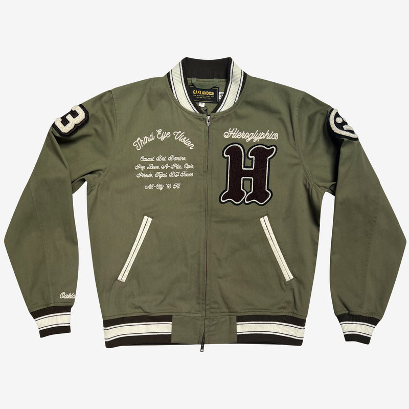 Front view of a zip-up cadet jacket with chenille Hiero Collective logo, wordmark patches on both sleeves, and left chest and third eye vision copy in cursive.