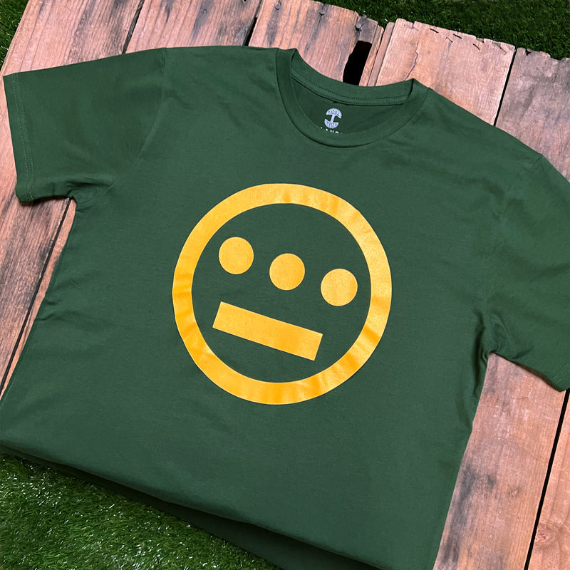Green t-shirt with yellow Hieroglyphics Hip-Hop logo on center chest on wood deck.