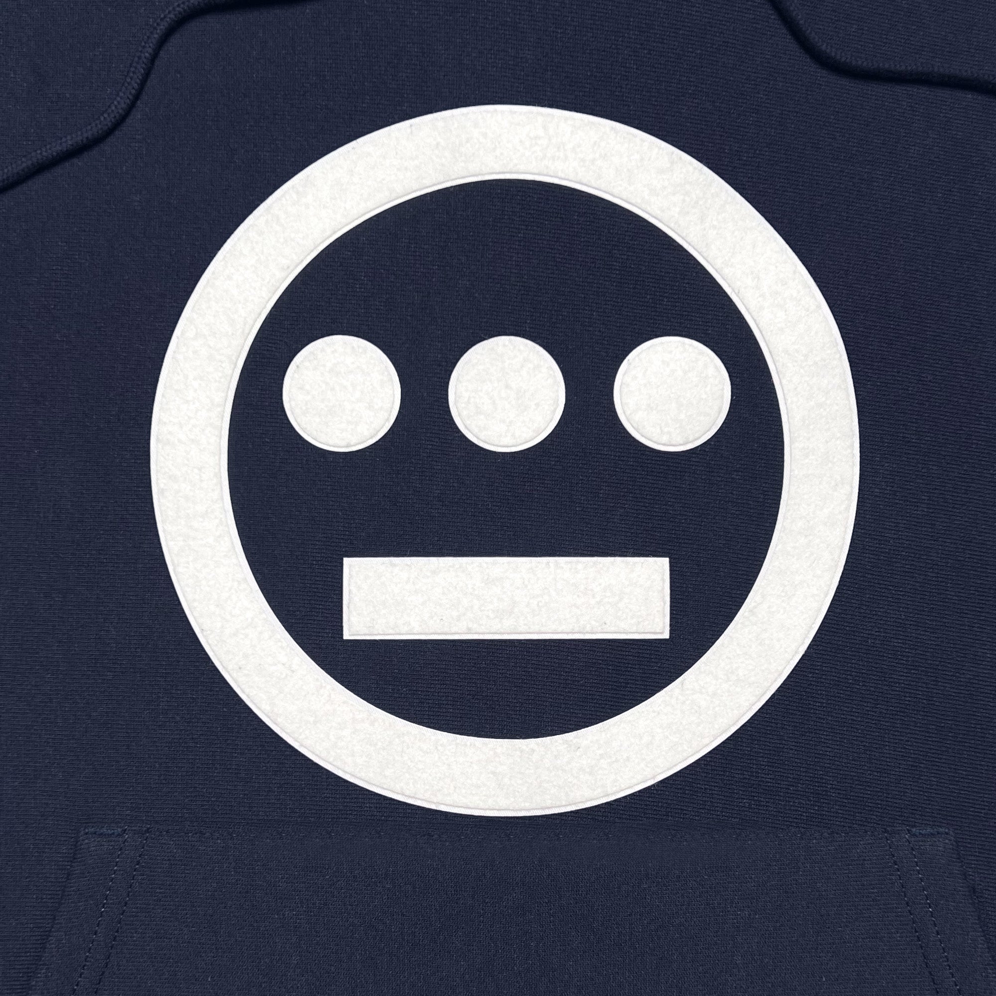 Detailed close-up of white Hieroglyphics hip-hop logo on the chest of a navy hoodie.