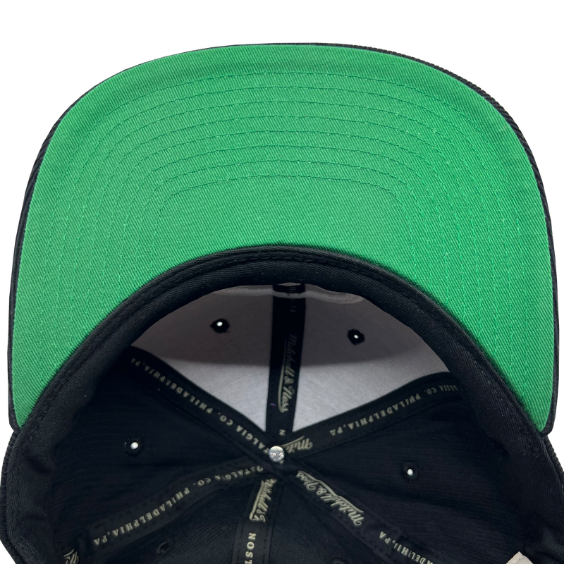 Detailed close up of green under visor and crown taping in a Mitchell & Ness cap.