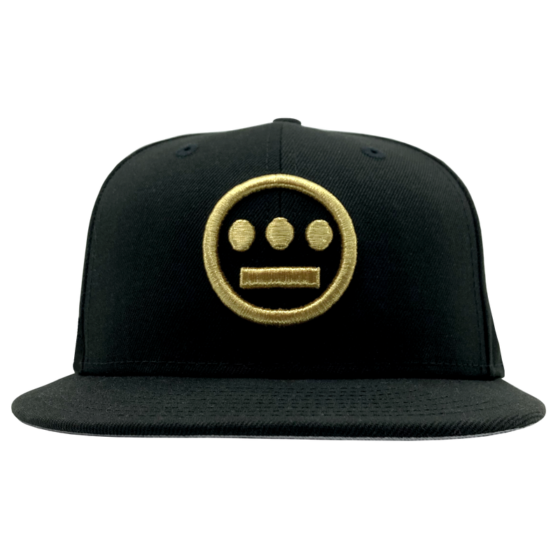 Front view of black New Era fitted cap with gold embroidered Hiero hip-hop logo on the crown.