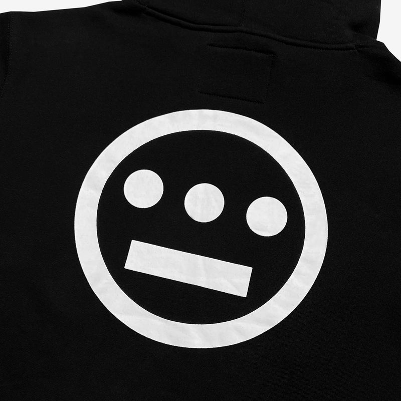 Close-up of a large white Hieroglyphics hip hop logo on the back of a black hoodie.
