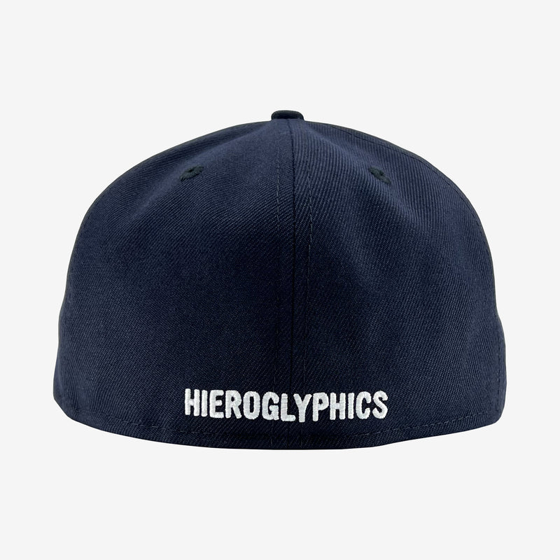 The backside of a navy fitted New Era cap with embroidered Hieroglyphics wordmark.