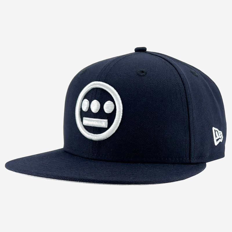 Side view of navy New Era cap with white embroidered Hieroglyphics hip-hop logo on the crown.