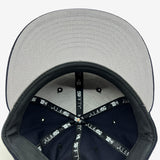 Grey undervisor and inside the crown of navy fitted New Era cap with taping with 59FIFTY New Era wordmark on repeat. 