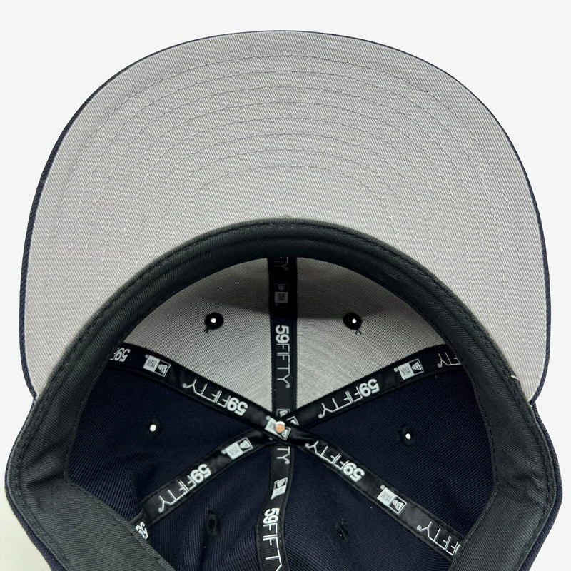 Grey undervisor and inside the crown of navy fitted New Era cap with taping with 59FIFTY New Era wordmark on repeat. 