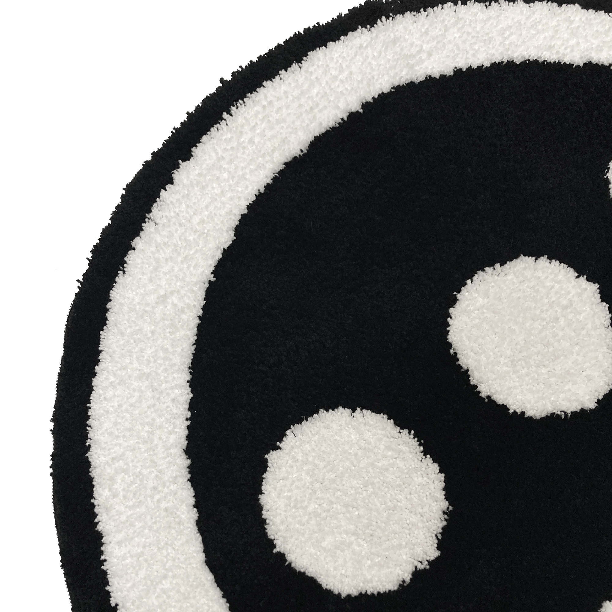 Detailed close up of round area rug with Hiero logo in black and white.