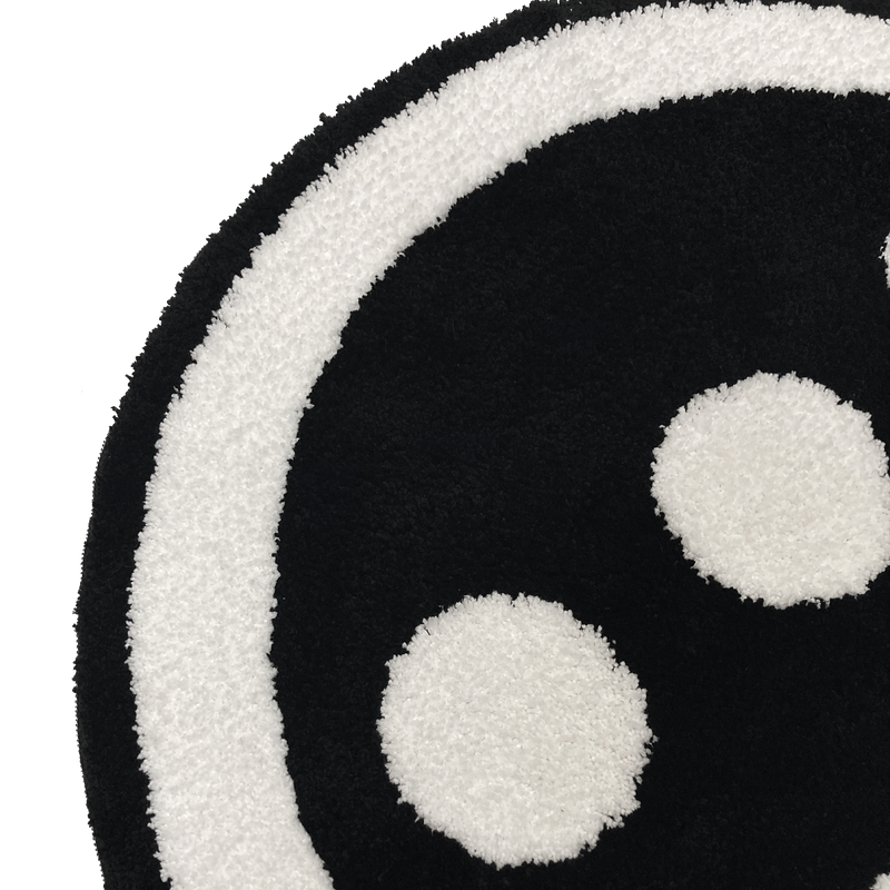 Detailed close up of round area rug with Hiero logo in black and white.