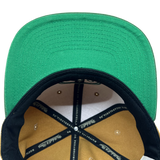 Detailed close-up of green undervisor and taping inside the crown of a Hiero hip hop X Mitchell & Ness cap.