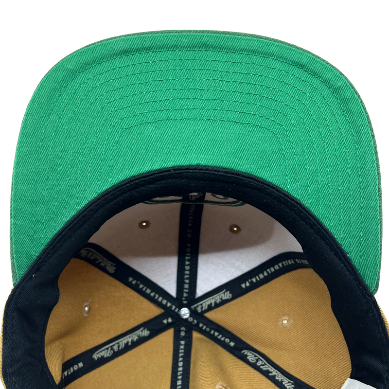 Detailed close-up of green undervisor and taping inside the crown of a Hiero hip hop X Mitchell & Ness cap.