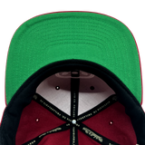 Detailed close-up of green undervisor and taping inside the crown of a Hiero hip hop X Mitchell & Ness cap.