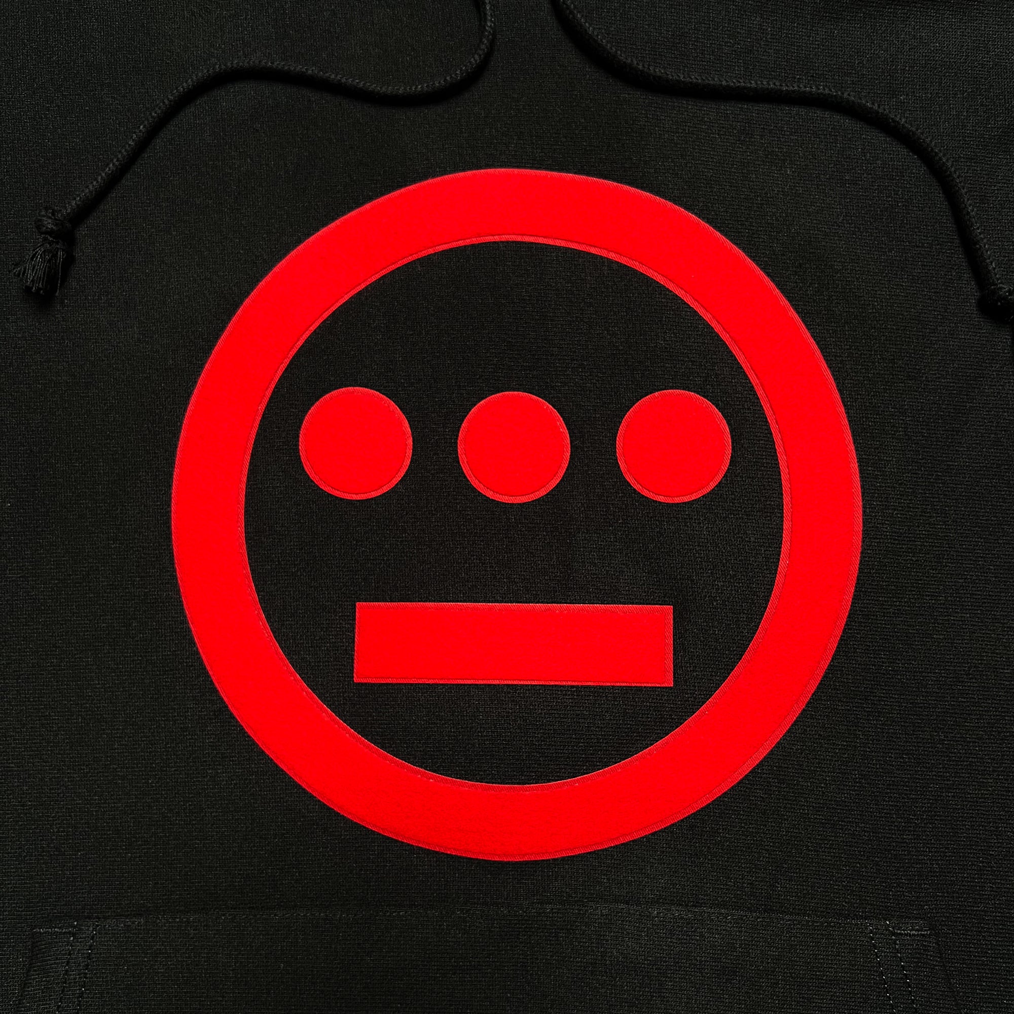 Close-up of red Hieroglyphics on the chest of a black hoodie.