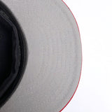 The grey underside of the bill of a New Era navy cap.