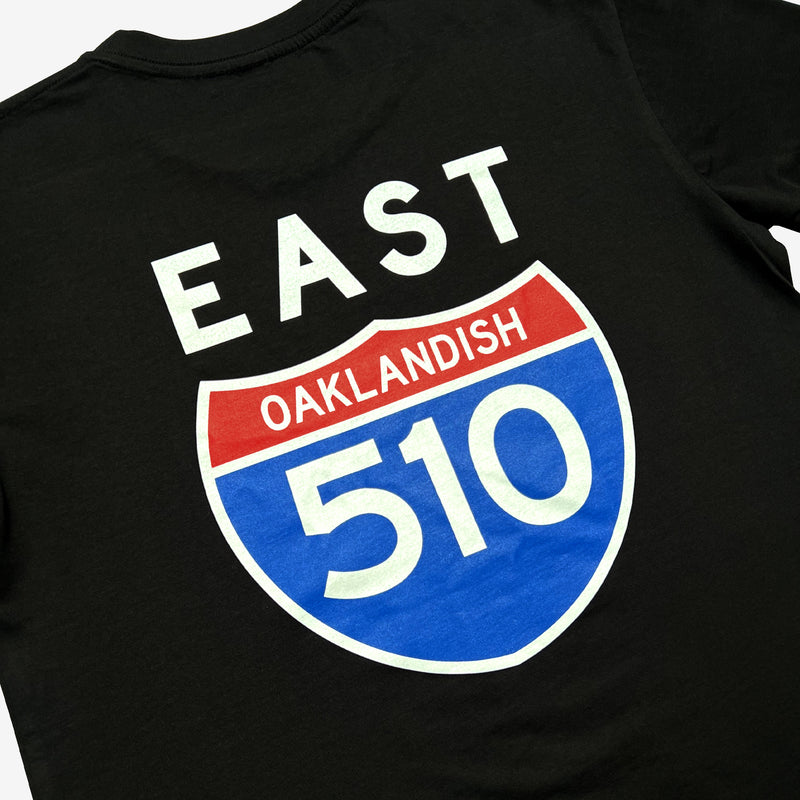 Close up of black t-shirt with 510 East Oakland Interstate highway sign on back of shirt with words Oaklandish and East. 