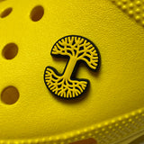 Yellow and black Oaklandish tree logo shoe charm on a yellow crock shoe.