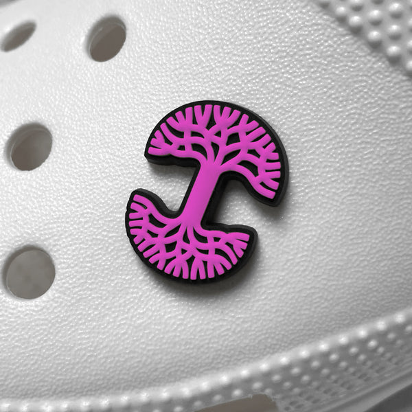 Pink and black Oaklandish tree logo shoe charm on a white croc clog.