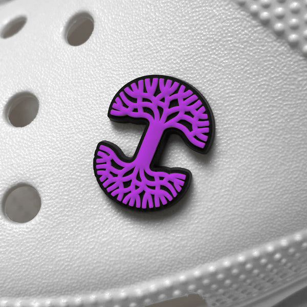Purple and black Oaklandish tree logo shoe charm on a white croc clog.