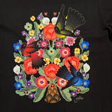 Close up of flowers and birds graphic on a black t-shirt designed by artist Jet Martinez. 