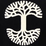 Detailed close-up of large white Oaklandish tree logo on the back of a black, heavy-knit sweater.