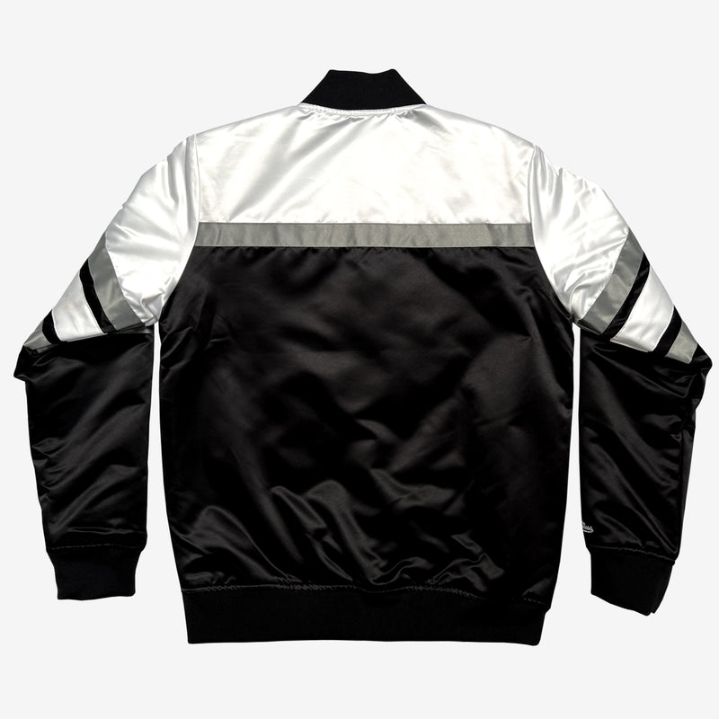 The backside of a black, white, and grey striped, collared satin jacket.